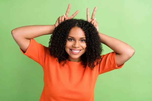 Photo of young black woman happy positive smile show fingers ears animal playful isolated over green color background.