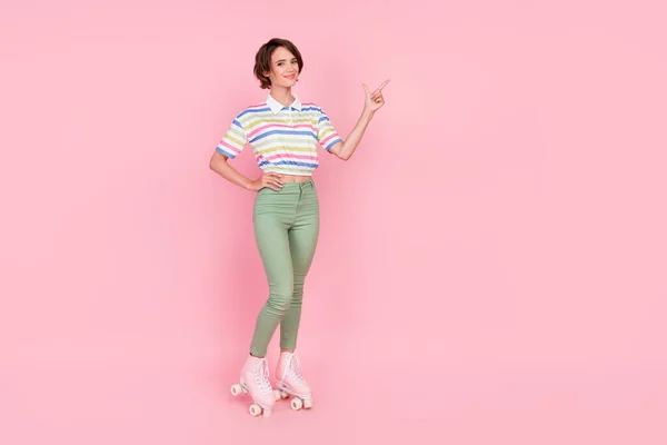 フルボディ写真の若いです女の子幸せな笑顔ローラースケートポイント指空スペース広告選択絶縁上ピンク色背景 — ストック写真