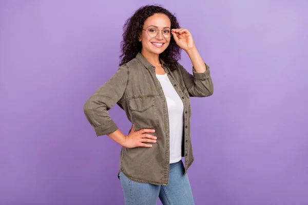 Photo of cheerful happy young afro american woman wear spectacles hand waist smile isolated on violet color background.
