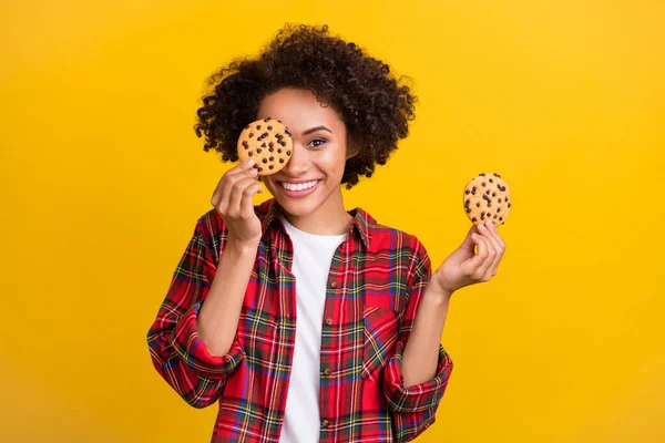 魅力的な面白い陽気な女の子の肖像画保持新鮮なおいしいクッキー閉じ目隔離された明るい黄色の色の背景 — ストック写真