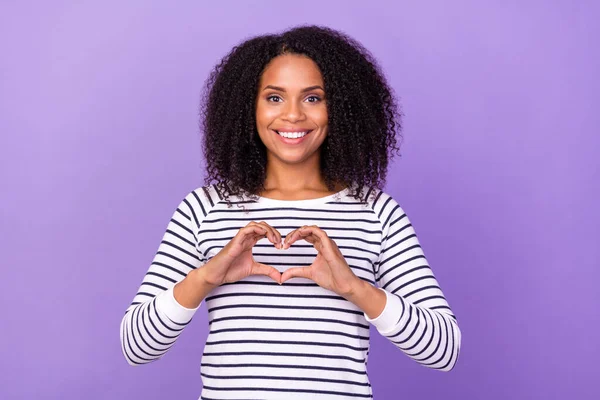 Photo of young smiling good mood woman showing heart symbol adore admire romance isolated on purple color background.