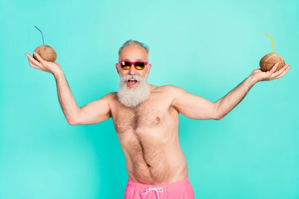 Photo of positive funny hipster old man dance hold cocktails wear sunglass shorts isolated teal color background.
