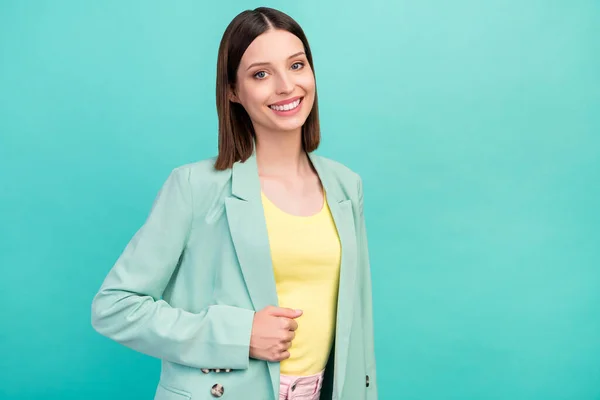 Portrait of gorgeous satisfied person beaming smile look camera hand touch blazer isolated on teal color background.