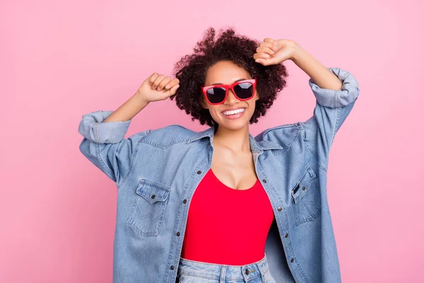Photo of carefree positive lady dance enjoy party wear sunglass denim jacket isolated pink color background.