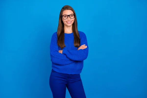 Portrait of attractive cheerful content girl executive assistant wearing jumper folded arms isolated over bright blue color background.