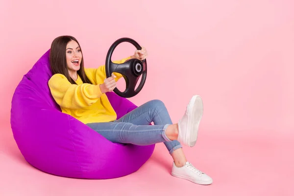 Full body profile side photo of young excited girl sit chair fast vehicle weekend isolated over pink color background.