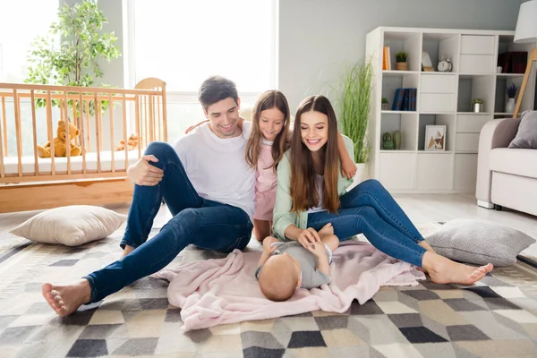 照片上滑稽迷人的丈夫妻子两个孩子坐在地板上 一起在屋里笑着回家的房子 — 图库照片