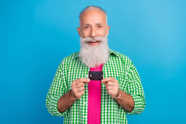 Photo of cheerful satisfied person hands hold demonstrate plastic debit card isolated on blue color background.