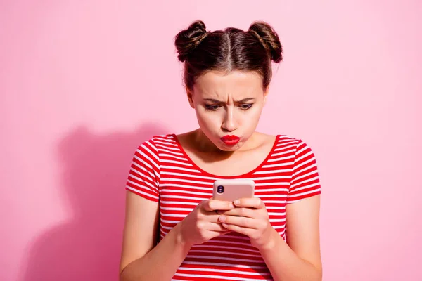 Photo of unhappy upset lady dressed striped t-shirt bloated cheeks typing modern device isolated pink color background.