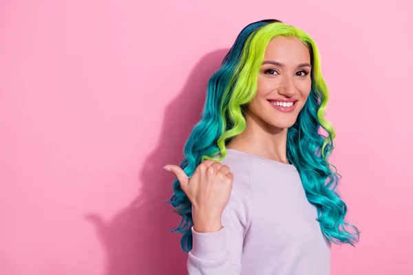Photo of young pretty good mood girl with gradient teal hair promote recommend product isolated on pink color background.