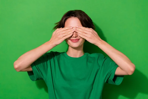 Portrait of satisfied person arms palms covering eyes play peekaboo isolated on green color background.