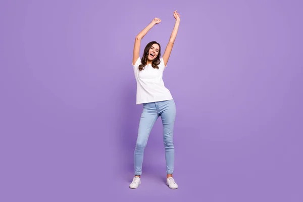 댄스를 여자가 보라색 배경에 고립된 티셔츠 청바지를 — 스톡 사진