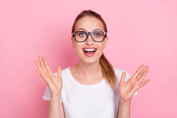 若い驚きの幸せな陽気な女性の写真手を上げるピンク色の背景に隔離された眼鏡を着用 — ストック写真