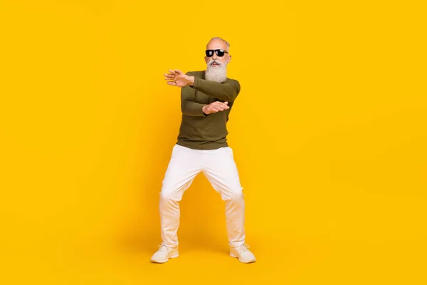Photo of crazy funky old man enjoy retro disco dance wear green shirt pants shoes isolated yellow color background.