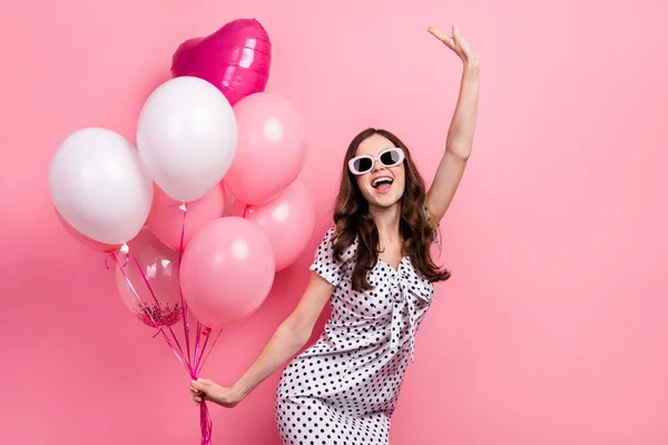 Photo of funny funky lady dressed dotted dress dark eyewear holding air balls dancing isolated pink color background.