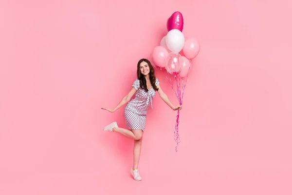 Photo of funky charming lady dressed dotted dress holding balloons dancing isolated pink color background.
