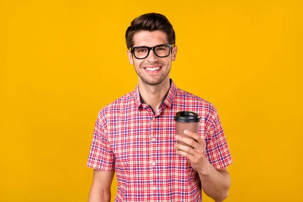 正の幸せな若い陽気な男の写真眼鏡を保持手コーヒーカップ笑顔黄色の色の背景に孤立 — ストック写真