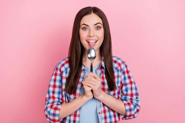 Photo of positive excited lady lick spoon feel hungry prepare yummy breakfast isolated on pink color background.