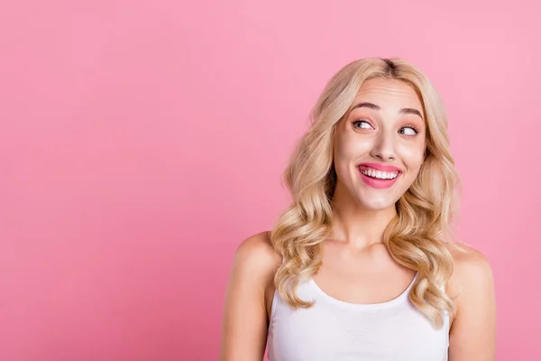 Portrait of attractive cheerful curious blond girl looking aside copy blank space ad isolated over pink pastel color background.