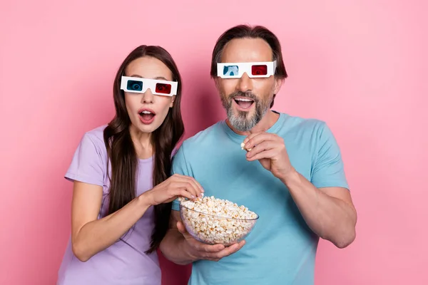 两个震惊的时髦人吃爆米花看电影3D眼镜的照片 眼镜背景为粉色 — 图库照片