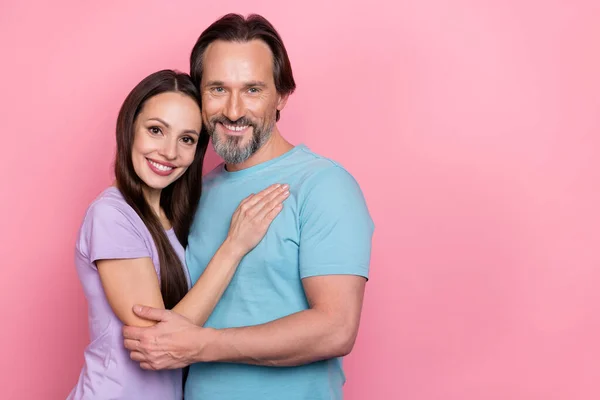 Photo of two peaceful positive people embrace toothy smile isolated on pink color background.