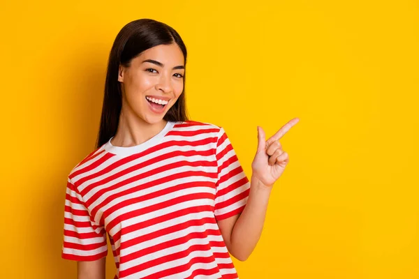 Portrait of cheerful funny person indicate finger empty space toothy smile wear red white isolated on yellow color background.