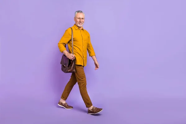 Full size profile side photo of mature man go hold briefcase manager isolated over violet color background.