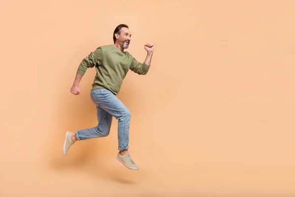 Full body profile photo of energetic excited person look empty space run fast isolated on beige color background.