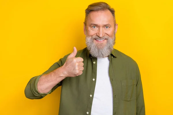Portrait of cheerful friendly person arm demonstrate thumb up toothy smile isolated on yellow color background.
