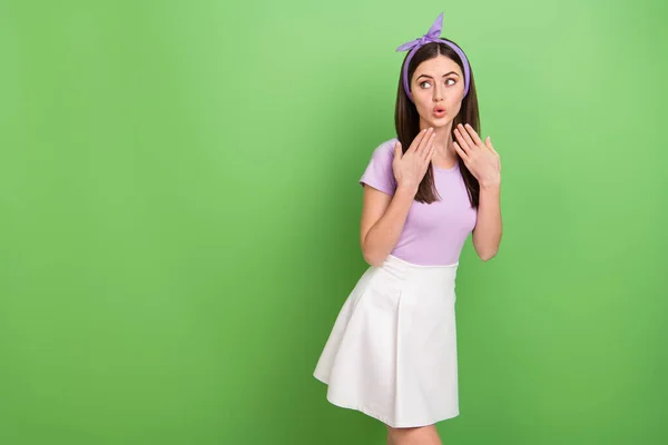 Photo of dreamy impressed lady dressed purple t-shirt hairband looking empty space isolated green color background.