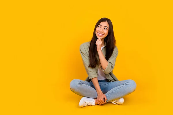 Full body portrait of minded positive lady arm touch chin toothy smile look empty space isolated on yellow color background.