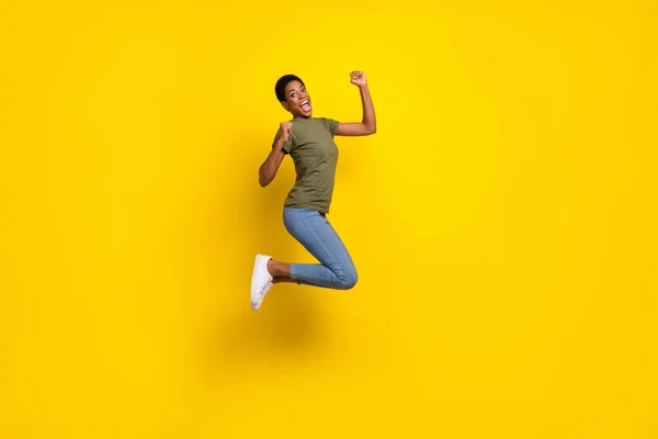 快乐人跳跃的全长肖像举起拳头庆祝以黄色为背景的胜利 — 图库照片