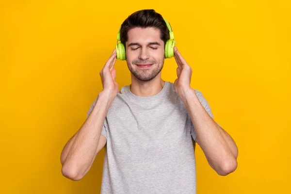 음악듣고 남자의 사진노란 배경에 고립된 이어폰 티셔츠를 — 스톡 사진