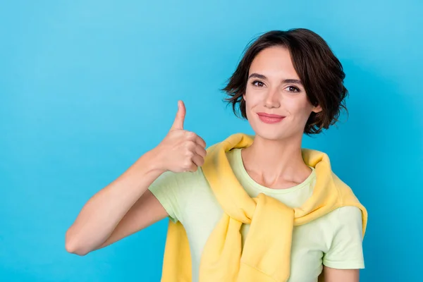 Photo of charming sweet woman wear green t-shirt showing thumb up isolated blue color background.