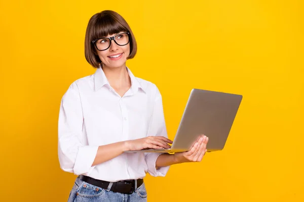梦幻般的自由职业者女士拿着手提电脑的照片空旷的空间穿着眼睛白衬衫孤立的黄色背景 — 图库照片