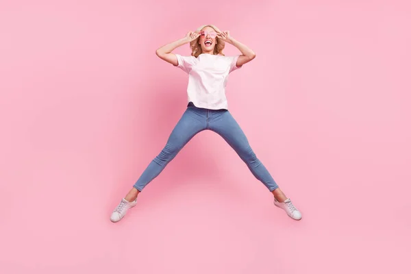 フルボディ写真の面白い若いですブロンド女性ジャンプ着用眼鏡Tシャツジーンズスニーカー隔離されたピンクの背景 — ストック写真