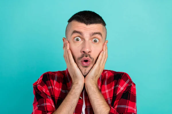 Photo of amazed shocked man hold hands face sale news reaction astonished isolated on teal color background.