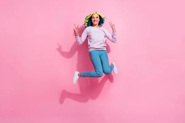 Full size photo of active energetic person jumping hands demonstrate v-sign symbol isolated on pink color background.