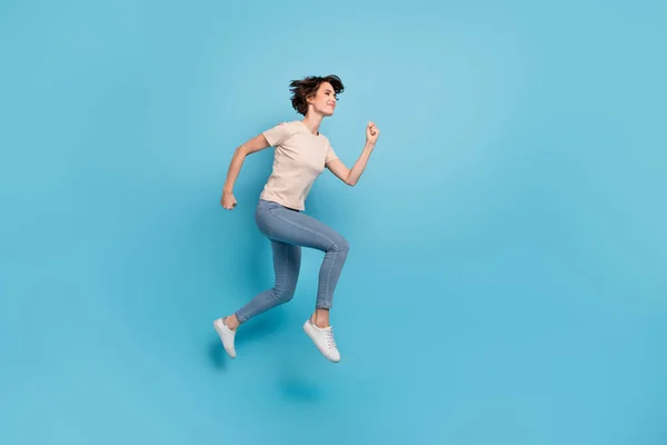 귀여운 아가씨가 공간에서 빠르게 베이지 티셔츠를 속도로 달리는 모습이 의푸른 — 스톡 사진