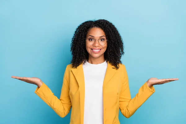 Photo of young black woman happy positive smile hold hands product promo ads isolated over blue color background.