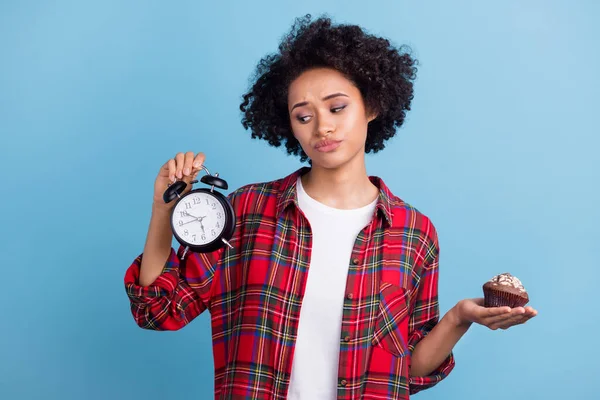 若いアフロの女の子の不幸な表情の時計を保持ケーキデザートシュガーダイエット青の色の背景に孤立 — ストック写真