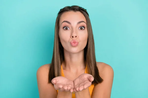 Photo of charming flirty happy young woman send air kiss you hands lips pouted isolated on teal color background.