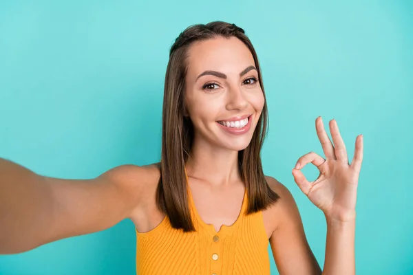Photo of cheerful positive happy woman show okay sign recommend take selfie sale isolated on teal color background.