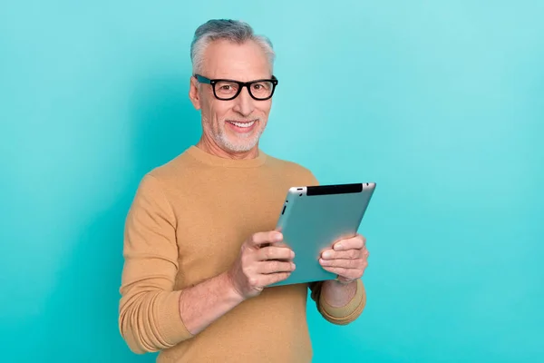 Photo of positive intelligent person hold tablet toothy smile look camera isolated on teal color background.