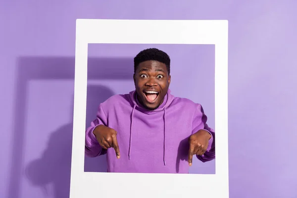 Photo of shocked funny person direct finger down empty space open mouth isolated on purple color background.