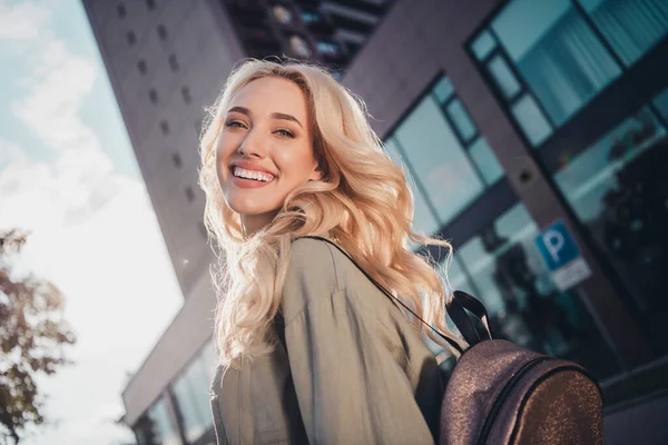 Profile side view portrait of attractive blond cheerful girl good mood strolling going to university study in town outdoors.