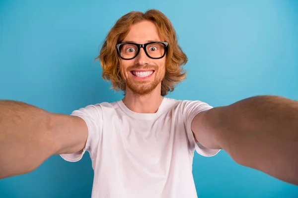Portrait of funky satisfied man make selfie recording video toothy smile isolated on blue color background.