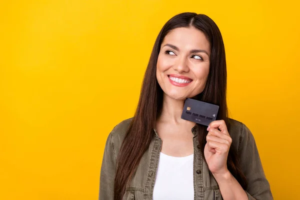 照片上的地雷梦幻般快乐的年轻女子看上去空荡荡的 空荡荡的 手里拿着用黄色背景隔开的信用卡 — 图库照片