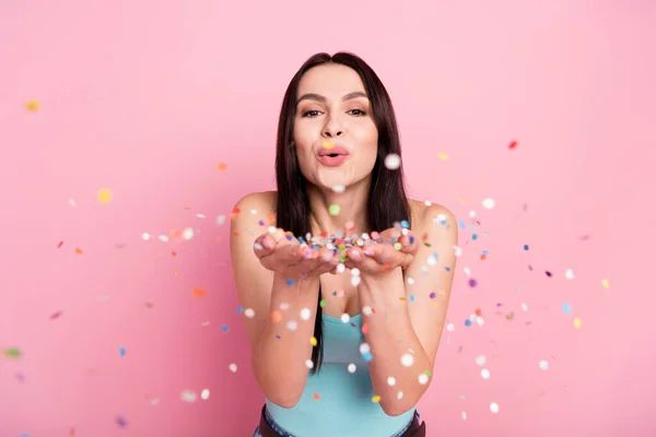 Photo of girlish millennial party lady blow confetti wear blue top isolated on pink color background.