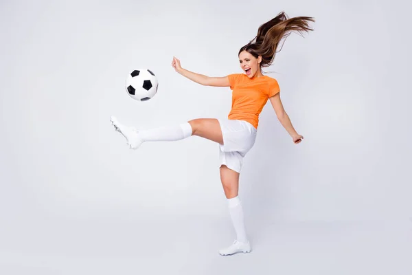 Full body profile photo of excited lady goalkeeper player team 2020 league game kick ball scream wear football orange uniform t-shirt shorts cleats socks, isolated white color background
